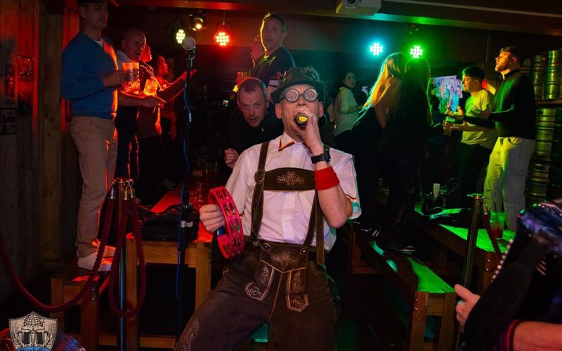 The Bierkeller Schunklers playing live, a singer in lederhosen with a tambourine at the front